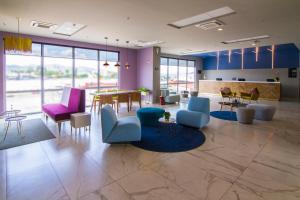 a lobby with chairs and tables and a dining room at City Express Plus by Marriott Mundo E in Mexico City