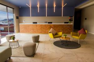 a lobby with chairs and tables and a counter at City Express Plus by Marriott Mundo E in Mexico City