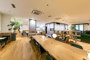 a restaurant with a long wooden table and chairs at Sotetsu Fresa Inn Kawasaki-Higashiguchi in Kawasaki