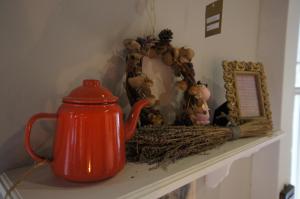 une bouilloire de thé orange assise sur une étagère avec un miroir dans l'établissement Brulee's Done, à Dongshan