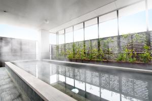 伊勢的住宿－伊勢市伊勢神宮酒店，一座种植了植物的游泳池