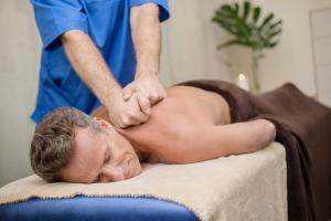 een man die een massage krijgt van een therapeut bij Health & Wellness Center Energetikas in Šventoji