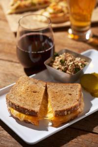 a sandwich on a plate with a salad and a glass of wine at Hyatt Place Santa Fe in Santa Fe