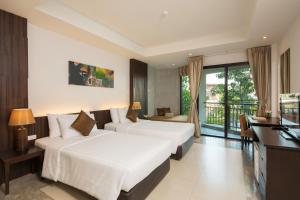 i Tara Resort & Spa في هاد تشاو سمران: غرفة فندقية بسريرين وبلكونة