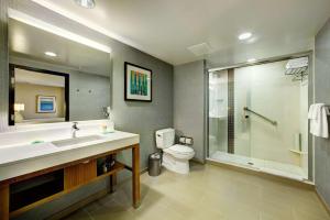 a bathroom with a toilet, tub, sink and shower at Hyatt Place UC Davis in Davis