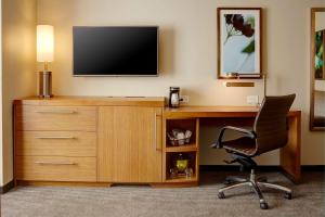 a room with a desk with a television and a chair at Hyatt Place New York Yonkers in Yonkers