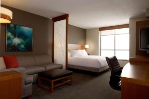 a hotel room with a bed and a couch at Hyatt Place DFW in Irving