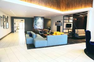 a living room with a blue couch and yellow chairs at Hyatt Place Austin Airport in Austin