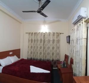 Hotel Daisy Park في بهيراهاوا: غرفة نوم بسرير ومروحة سقف