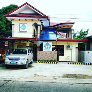 un coche blanco estacionado frente a un edificio en Mariner's Pension House en Puerto Princesa