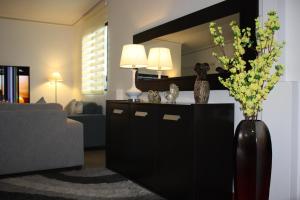 a living room with a vase of flowers and a mirror at Home Suite Garden in Guayaquil