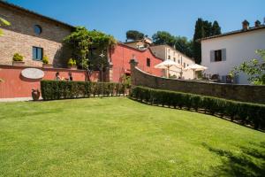 ein Hof mit einem Zaun und einigen Gebäuden in der Unterkunft Borgo Grondaie in Siena