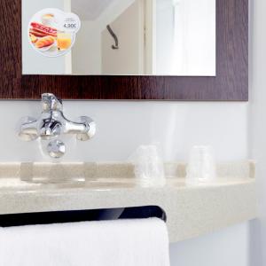 a bathroom sink with a mirror and a towel at Première Classe Troyes Sud - Buchères in Buchères