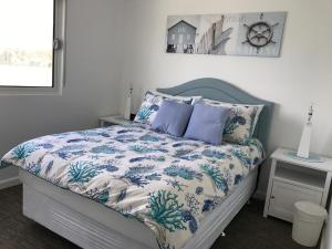 1 dormitorio con 1 cama con edredón azul y blanco en Marina View Chalets, en Wannanup