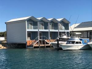 boats docked at a dock in front of a large building at Marina View Chalets in Wannanup