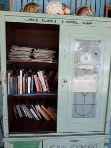 a book shelf filled with books next to a door at Tahan Guest House in Kuala Tahan