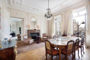 a dining room with a table and a living room at Haussmann 168 in Paris