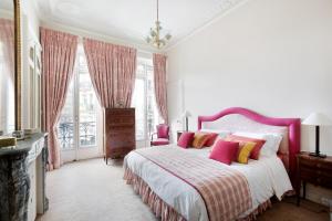 a bedroom with a large bed with pink and yellow pillows at Haussmann 168 in Paris