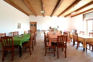 a dining room with tables and chairs and a kitchen at Agriturismo con Trullo in Alberobello