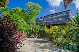 um jardim com plantas e um edifício em Horisun em Belle Mare