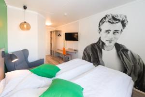 a bedroom with a bed with a picture of a man at Fjordgaarden Mo in Mo i Rana