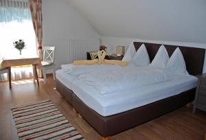 タムスヴェークにあるPension Weberのベッドルーム(白いシーツを使用した大型ベッド1台付)