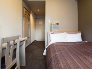 東京にあるホテルルートイン東京池袋のベッドと廊下が備わるホテルルームです。