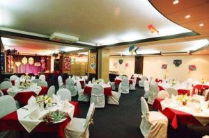 a banquet hall with white tables and white chairs at La Vinci Hotel in Dhaka