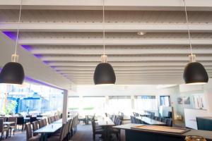 a dining room with tables and chairs and lights at Fjordgaarden Mo in Mo i Rana