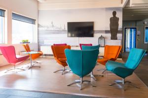 una sala conferenze con tavolo e sedie colorate. di Fjordgaarden Mo a Mo i Rana