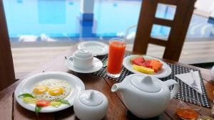 a table with eggs and fruit and a pitcher of juice at Leighton Resort in Negombo