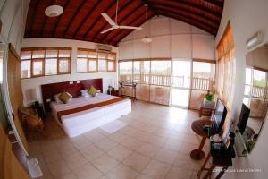 a bedroom with a bed in a room with windows at Marina Bentota in Bentota