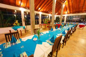 a long table with blue tables and chairs in a building at Marina Bentota in Bentota