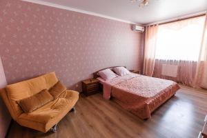 クラスノダールにあるApartment on Pokryshkina 2のベッドルーム1室(ベッド1台、椅子付)