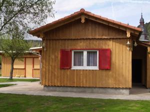 ein kleines Haus mit einem Fenster und einem roten Rollladen in der Unterkunft Berliner Hütte in Neustadt