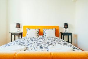 a bedroom with an orange bed with two side tables at Artsy Old Town Apartment in Bucharest