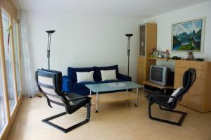 sala de estar con sofá, mesa y sillas en Ferienwohnung Mura, en Vals