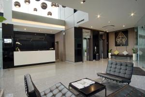 a lobby with two chairs and a reception desk at Malioboro Prime Hotel in Yogyakarta