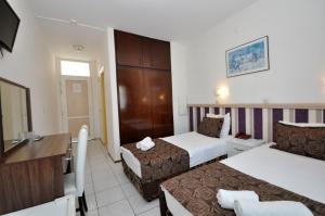 a hotel room with two beds and a television at Reis Maris Hotel in Marmaris