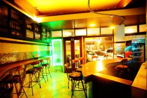 a bar in a restaurant with green lights at Kenya Comfort Hotel in Nairobi