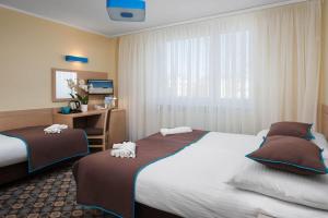 ヤストシェンビャ・グラにあるDom Wczasowy VISのベッド2台とデスクが備わるホテルルームです。
