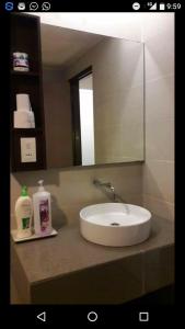 W łazience znajduje się umywalka i lustro. w obiekcie Mama Studio Inn w mieście Kota Bharu
