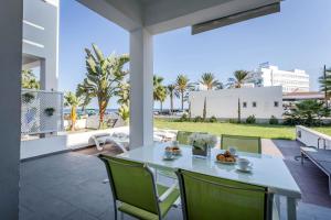 einen weißen Tisch und Stühle auf einer Terrasse mit Palmen in der Unterkunft Villa Nora in Protaras