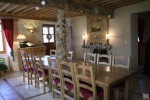 La ferme du Château في Saint-Martin-en-Vercors: غرفة طعام مع طاولة وكراسي خشبية