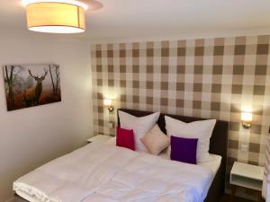 a bedroom with a white bed with purple pillows at Ferienhaus Alpenperle in Grainau