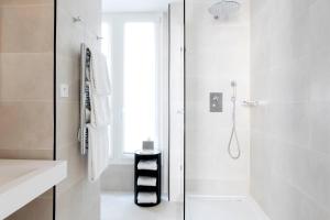 a white bathroom with a shower and a window at Hôtel Mathis Elysées in Paris
