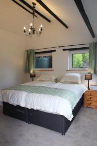 a bedroom with a large bed and a chandelier at Little Trewin in Helston
