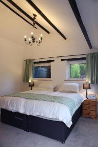 um quarto com uma cama grande e 2 janelas em Little Trewin em Helston