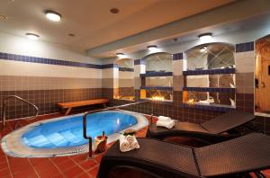 - une baignoire jacuzzi dans une chambre dotée de carrelage bleu dans l'établissement Hotel Zátiší, à Špindlerův Mlýn