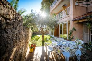 a table and chairs on the patio of a house at Celtis Apartment in Mlini